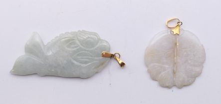 Two gold mounted jade fish form pendants. The largest 6 cm high.