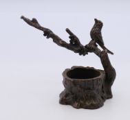 A bronze model of a bird in a tree. 6 cm high.