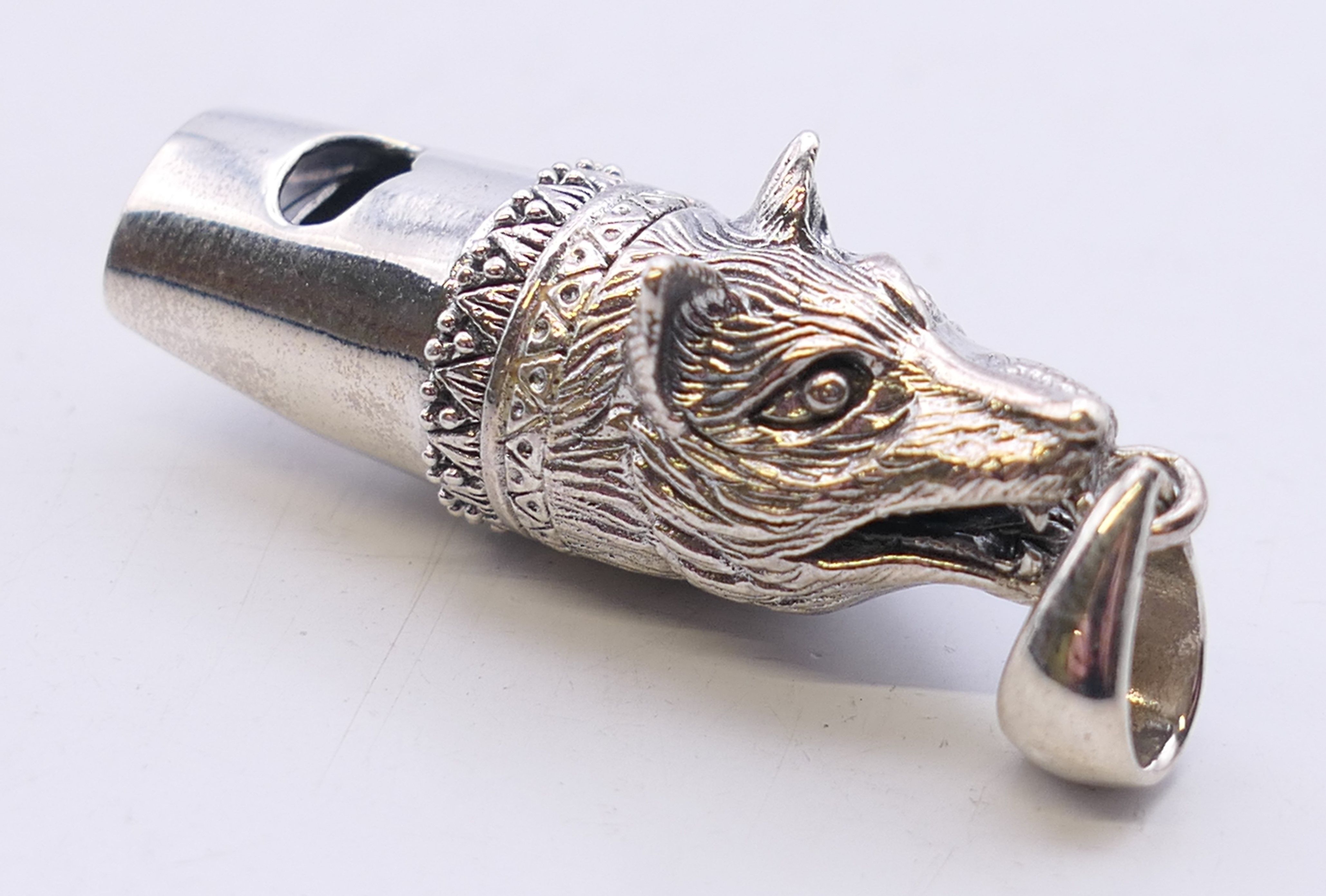 A silver fox mask whistle. 4.5 cm long overall.