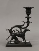 A bronze candlestick surmounted with a dog. 21 cm high.