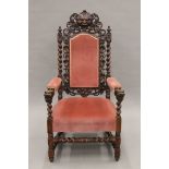 A 19th century carved oak upholstered open armchair with greenman back and dolphin form arms.