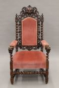 A 19th century carved oak upholstered open armchair with greenman back and dolphin form arms.