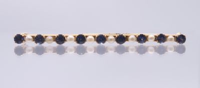 An antique natural sapphire and seed pearl bar brooch, tested high carat. 6 cm wide. 5.