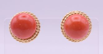A pair of 14 K gold coral earrings. Each 1.5 cm diameter.