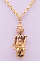 A 9 ct gold articulated clown form pendant on 9 ct gold chain. Clown 3 cm high, chain 40 cm long.