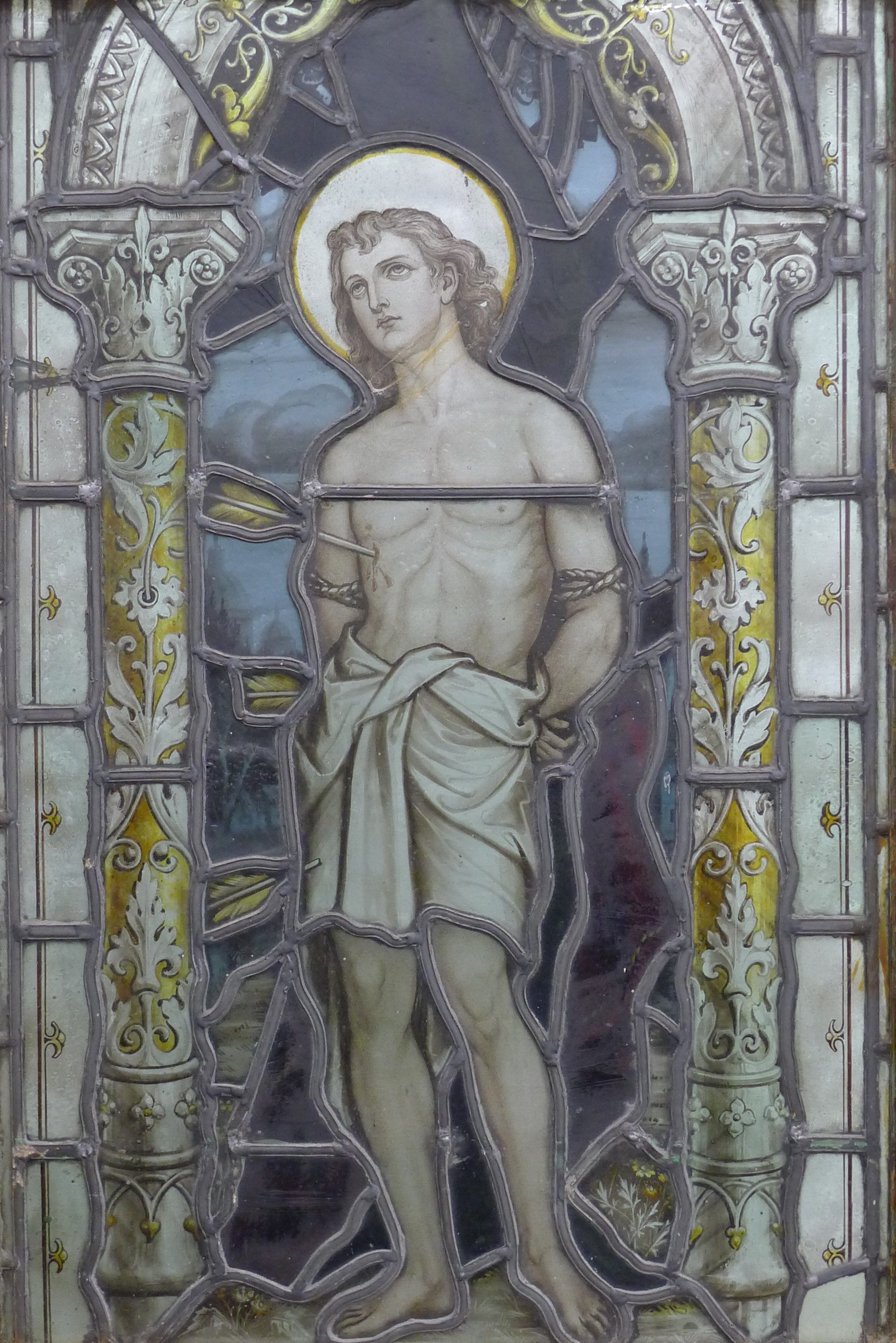 An antique stained leaded glass panel depicting the Martyrdom of Saint Sebastian,