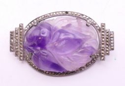 A silver and carved amethyst and marcasite brooch. 4.5 cm wide.