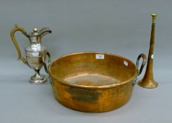 A copper jam pan, a copper horn and a silver plated ewer. The former 39 cm wide.
