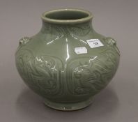 An Oriental celadon ground vase with dog-of-fo mask handles. 19 cm high.