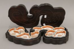 A 19th century Chinese porcelain hors d'oeuvre's set, housed in a carved box. The box 48.5 cm long.