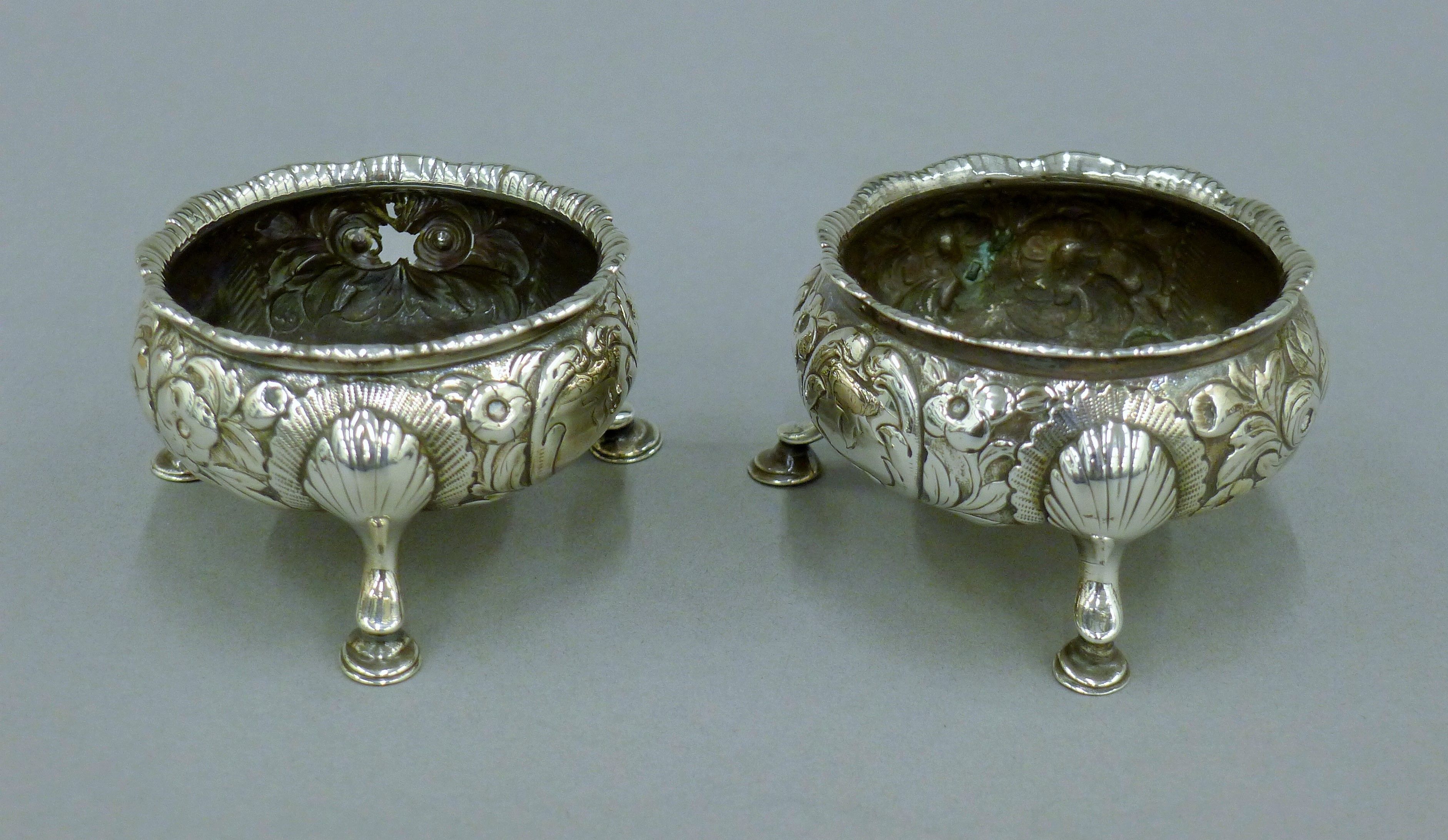 A pair of embossed Georgian silver salts. 7 cm diameter. 139.5 grammes.