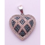 A 10 ct white gold diamond and sapphire heart form pendant. 2.75 cm high. 3.2 grammes total weight.