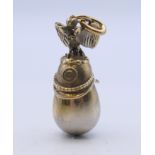 A silver helmet and egg pendant bearing Russian marks. 4.5 cm high.