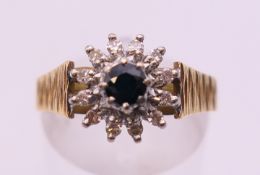 An 18 ct diamond and sapphire cluster ring. Ring size is O/P.