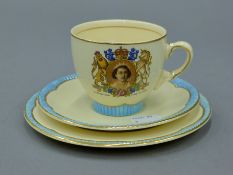 A Clarice Cliff Queen Elizabeth II Coronation trio. The plate 16.5 cm diameter.