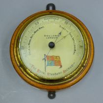 A Dolland of London wall barometer, the dial decorated with the Royal Standard. 16.5 cm diameter.