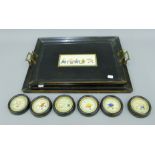 A pair of early 20th century ebonised trays and six matching coasters,