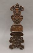 A 19th century carved walnut Sgabello chair, the shaped back worked with a vacant heraldic shield,