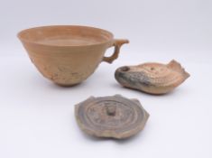 A Roman clay oil lamp of typical form,