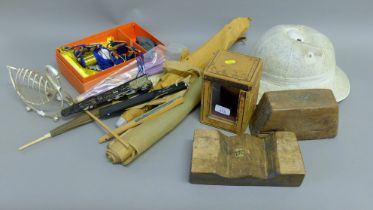 A box of miscellaneous items including a pith helmet, fans, a toast rack etc.