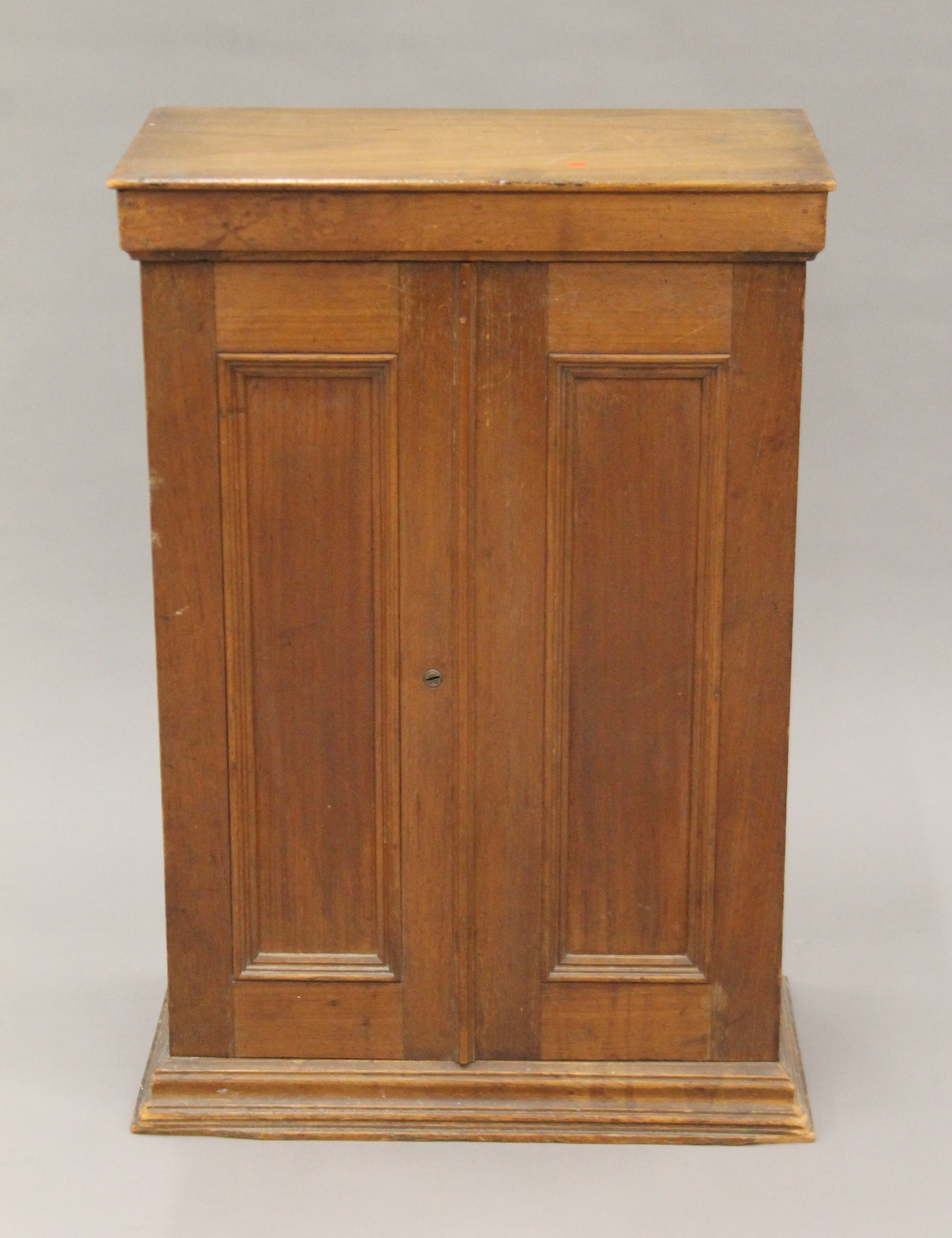 A late 19th century small walnut two-door cupboard. 45 cm wide x 66.5 cm high x 25.5 cm deep.