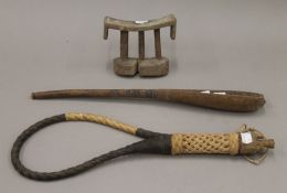 An African tribal wooden head rest, a scoop and a whip. The former 14 cm wide.