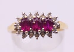 An 18 ct three-ruby and diamond ring. Ring size P/Q.