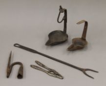 A quantity of old cast/wrought iron kitchenalia to include butter lamps, toasting fork, etc.