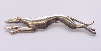 A silver greyhound brooch. 7 cm long.