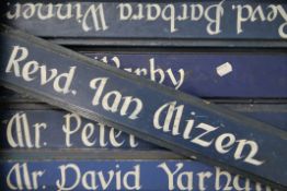 A quantity of sign written name boards, each approximately 58 cm long.