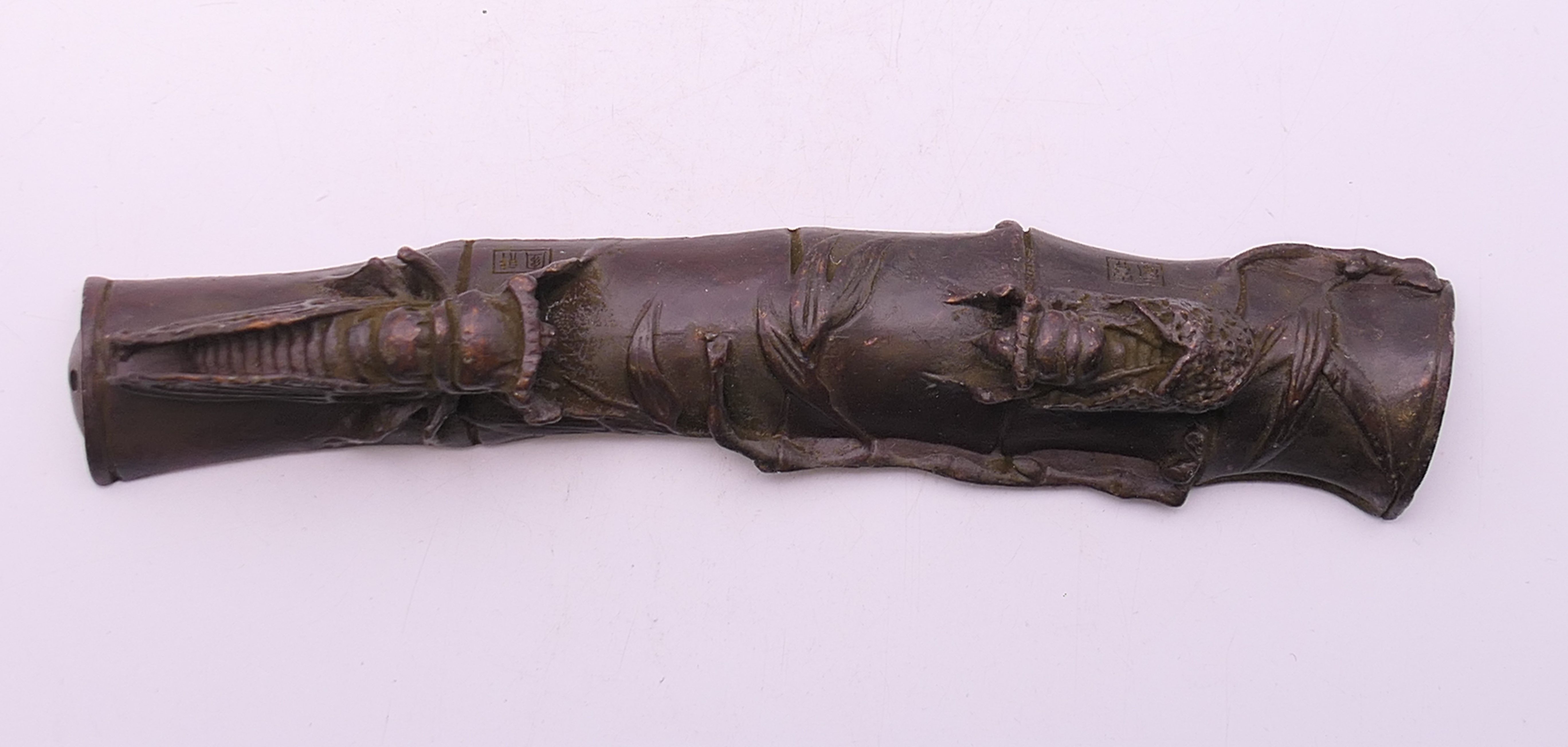 A bronze fly and locust scroll weight. 16 cm long.