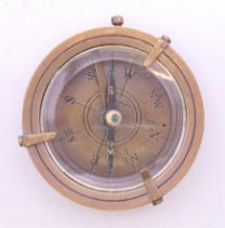 A brass compass, dial inscribed Dolland of London. 6.25 cm diameter.