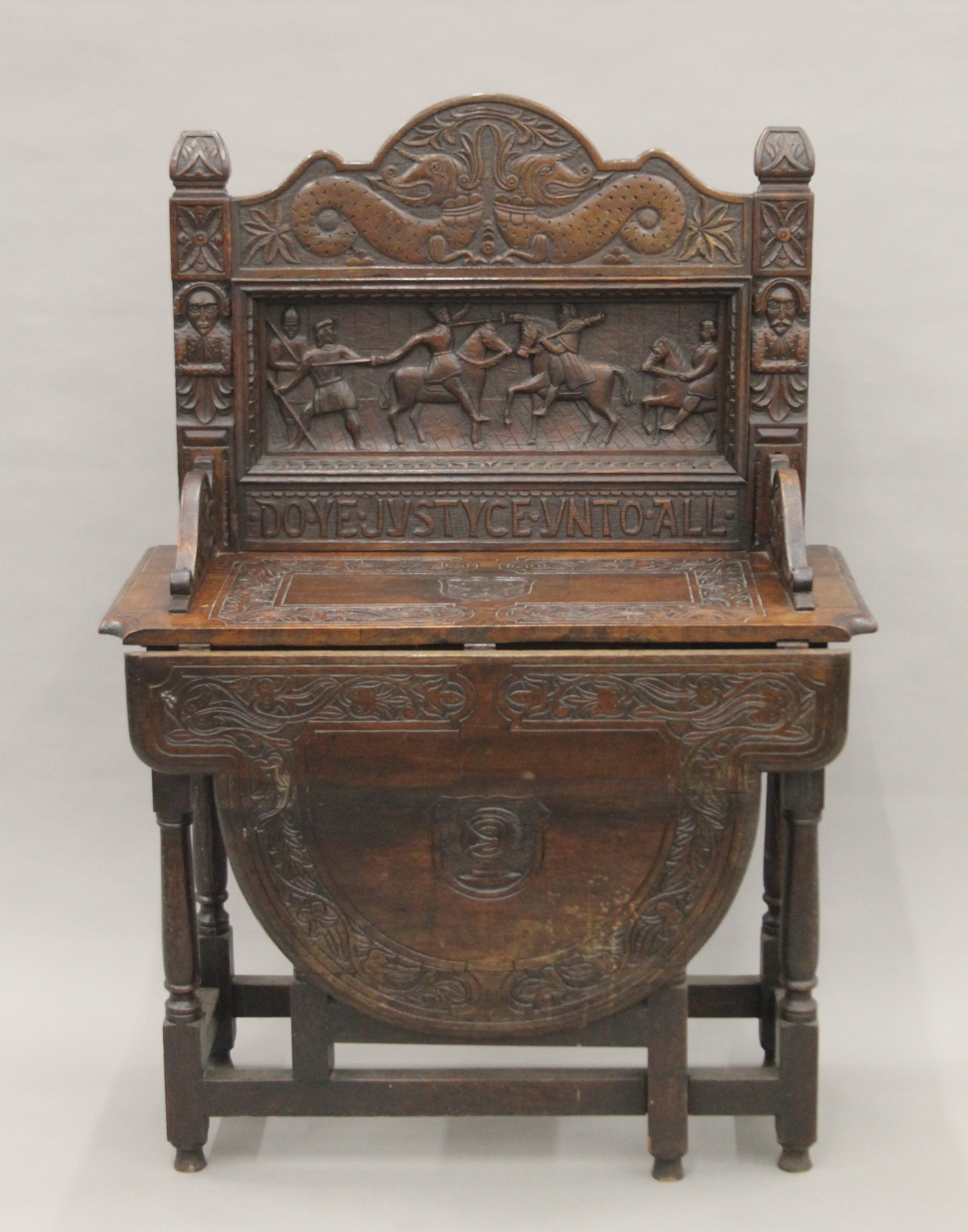 A carved oak single flap side table, the back carved with a scene titled Do Ye Justyce Unto All.