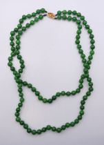 A double strand jade necklace with diamond and citrine-set clasp. 57 cm long.