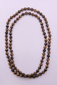 A string of tigers eye beads. 94 cm long.
