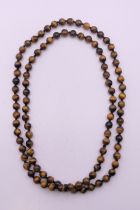 A string of tigers eye beads. 94 cm long.