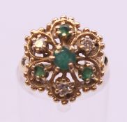 An unmarked gold emerald and diamond cluster ring. Ring size K/L. 3.9 grammes total weight.