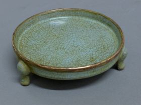 A Chinese celadon censer with copper rim. 14 cm diameter.