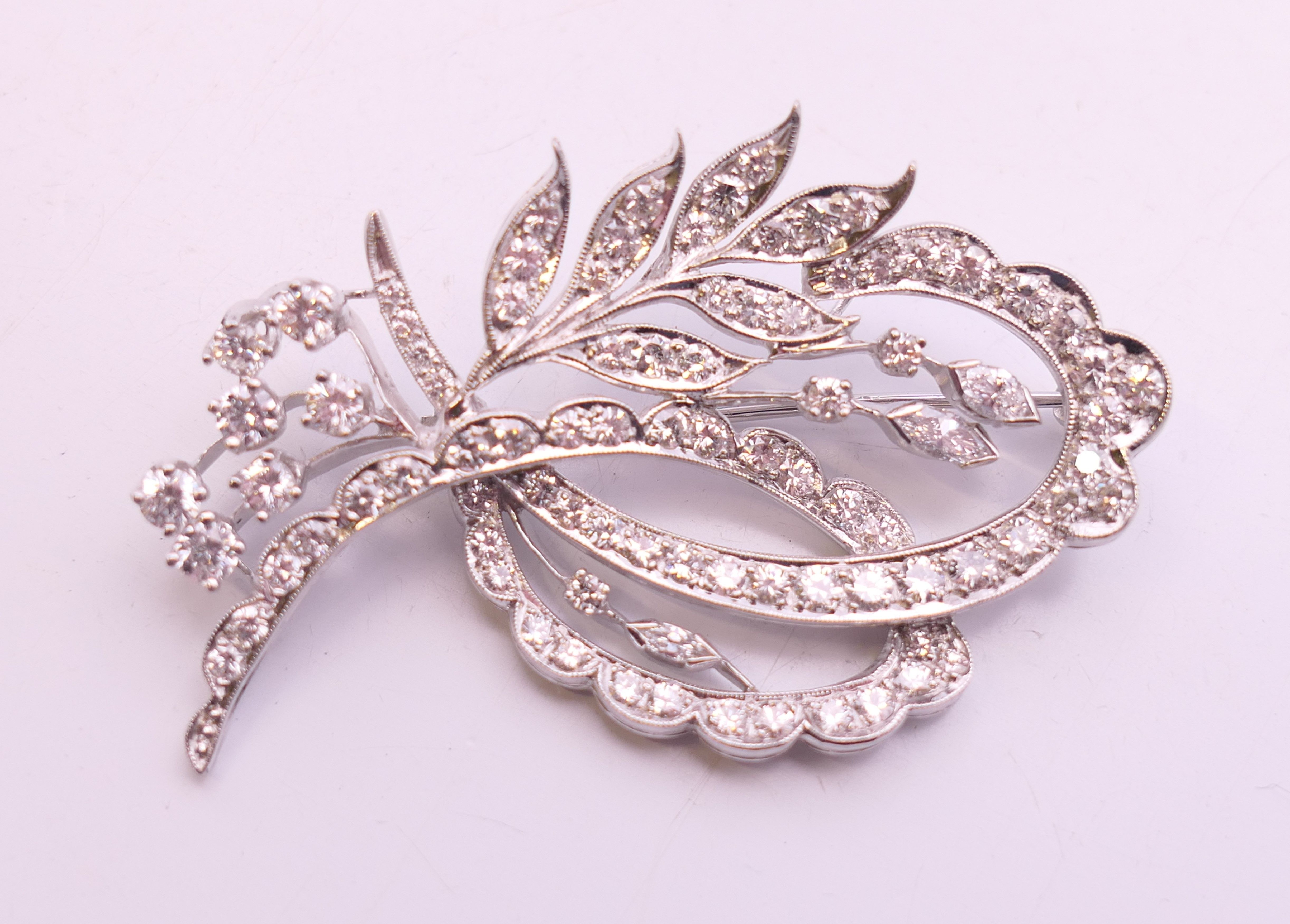 An unmarked white gold or platinum diamond-set floral spray brooch. 5 cm high.