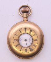 A 14 K gold stiffened half hunter pocket watch. 4 cm diameter.