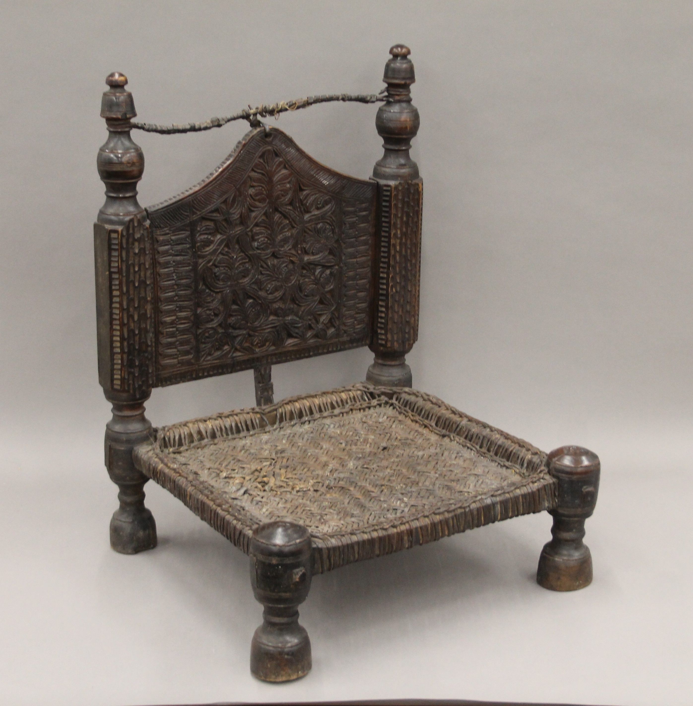 An Indian antique low hardwood chair with reeded seating. 64 cm high.