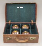 A vintage case containing four bowling woods. The case 45 cm wide.