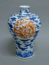 A Chinese blue and white vase with iron red dragons. 32.5 cm high.