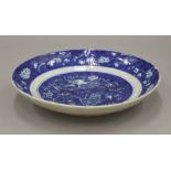 A Chinese blue and white porcelain dish decorated with a dragon. 28 cm diameter.