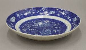 A Chinese blue and white porcelain dish decorated with a dragon. 28 cm diameter.
