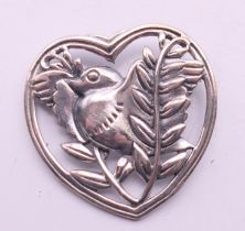 A silver heart and bird brooch. 3 cm wide.