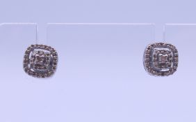 A pair of diamond stud earrings. 7 mm wide.