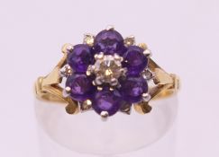 An 18 ct gold amethyst and diamond daisy cluster ring. Ring size M.