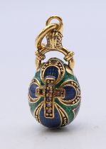 A silver and enamel egg pendant bearing Russian marks. 3 cm high.