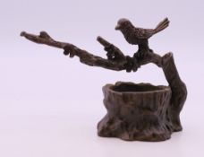 A bronze model of a bird in a tree. 5.5 cm high.